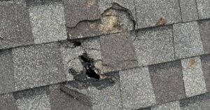 close-up-of-roof-shingle-puncture-from-storm-debris - Roof Fix Florida